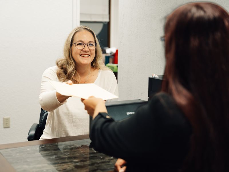 Passing a document across the reception desk, DM Tax & Bookkeeping