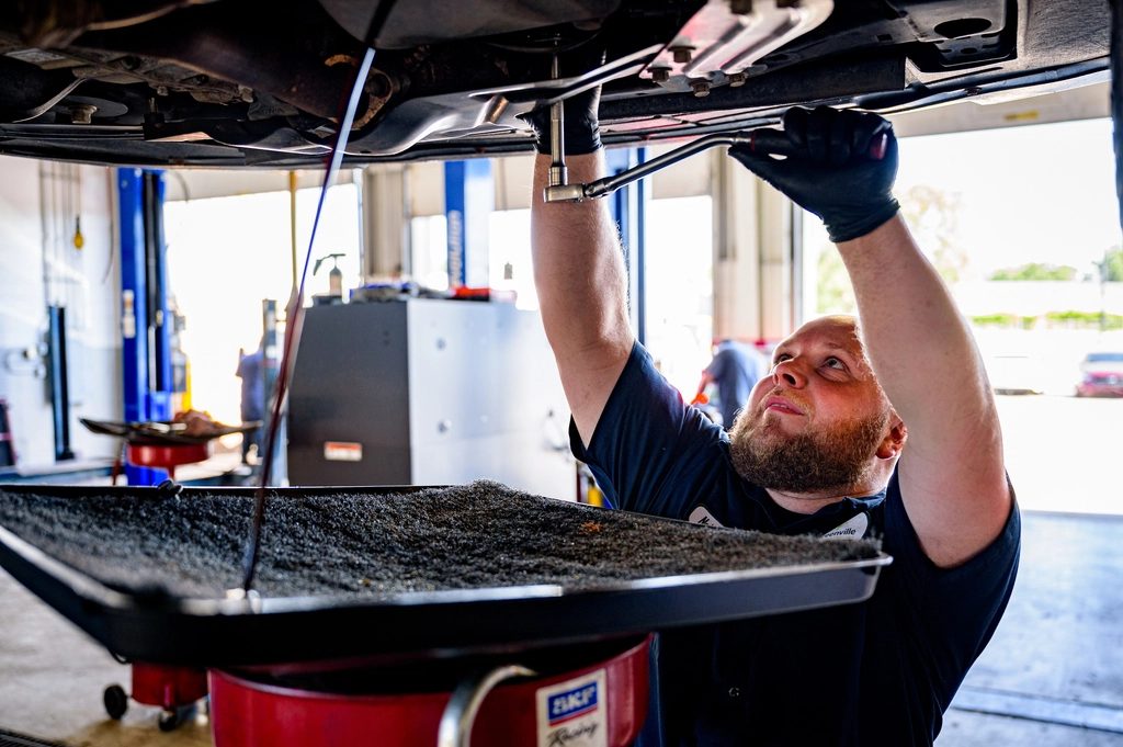 Mechanic working underneath a car on a lift