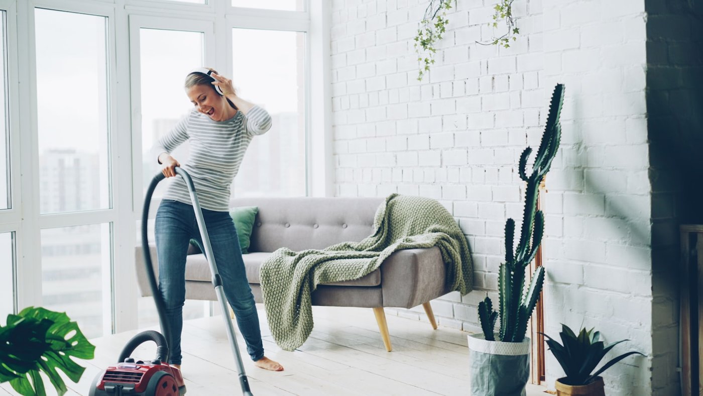 Professional cleaner vacuuming a bright living room