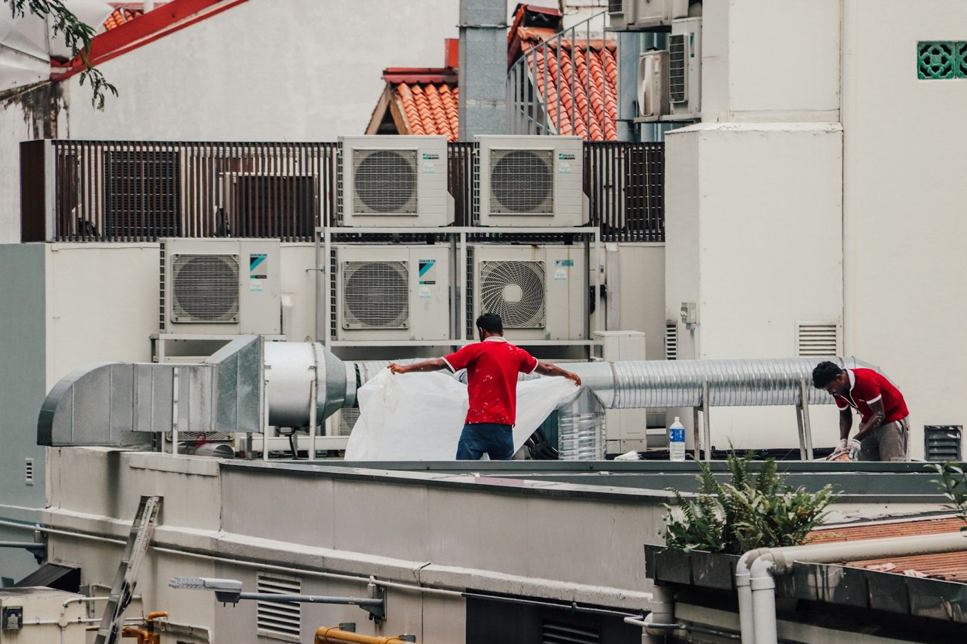 HVAC technicians servicing rooftop air-conditioning units