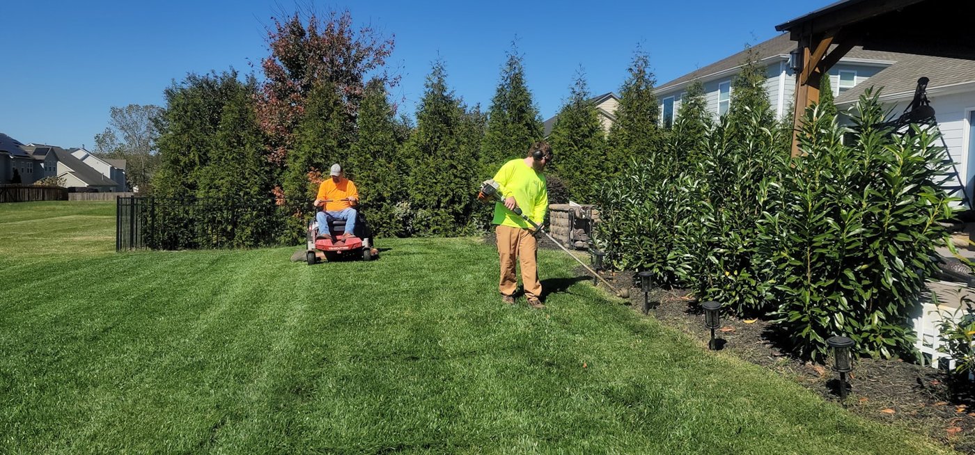 Landscaping crew mowing and maintaining a lawn