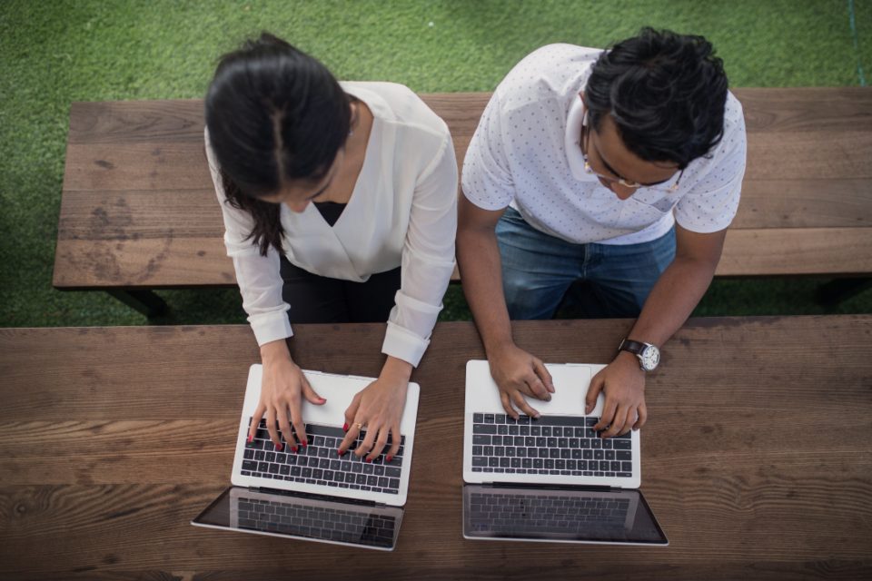Two business owners working on laptops