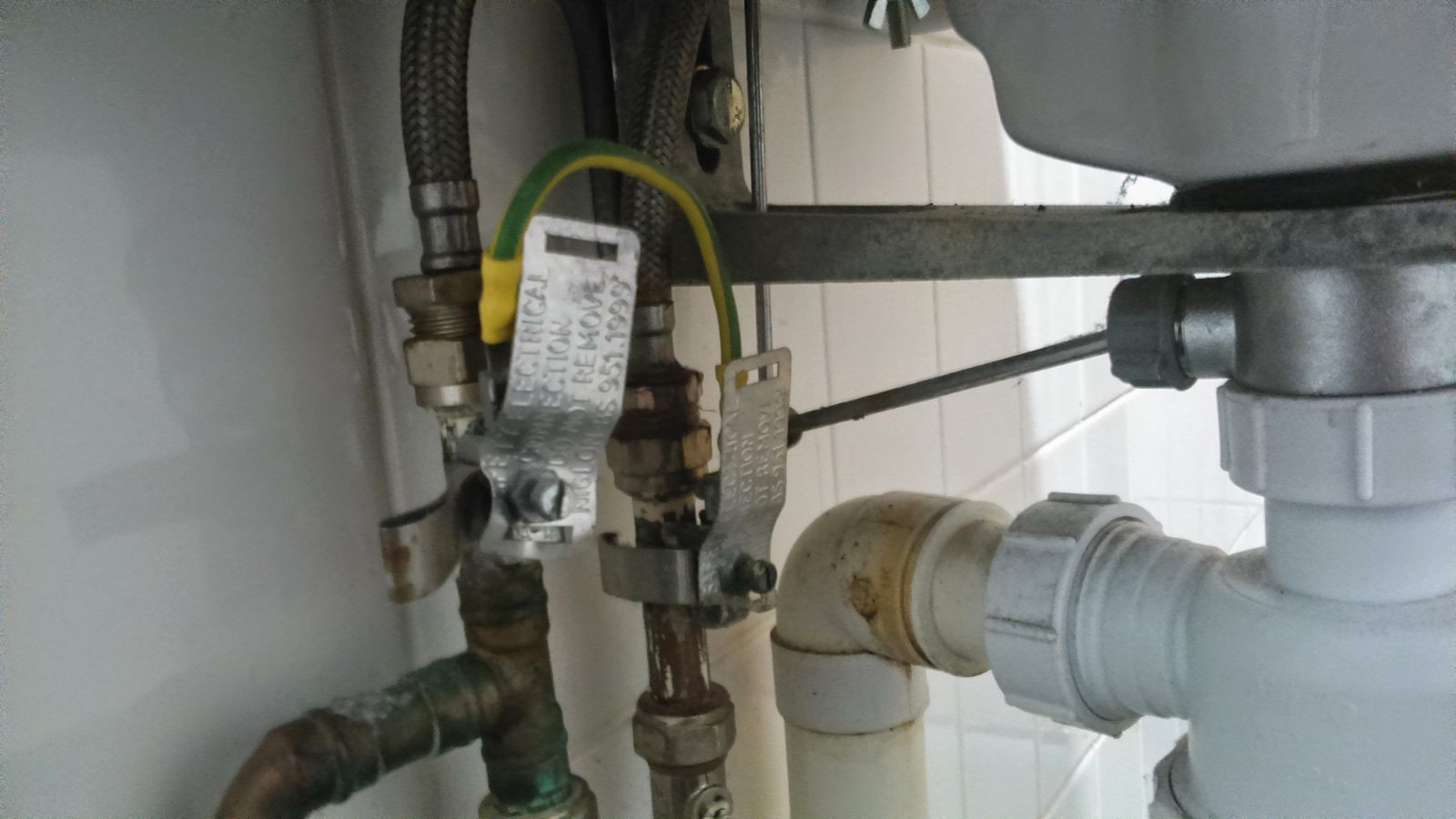Plumber working on copper pipes and a shut-off valve